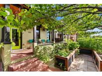 Inviting front porch with seating and vibrant greenery, showcasing the home's curb appeal at 3313 Curtis St, Denver, CO 80205