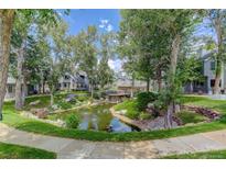 Scenic pond with surrounding greenery and townhomes creates a tranquil community atmosphere at 8500 E Jefferson Ave # 3H, Denver, CO 80237