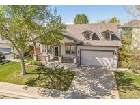 Charming home featuring a covered front porch, dormer windows, and a well-maintained lawn at 1404 Tonkin Pl, Longmont, CO 80504