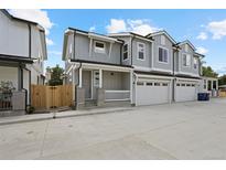 Attractive townhome with gray siding, white trim, covered porch, and attached garage at 4020 Upham St, Wheat Ridge, CO 80033