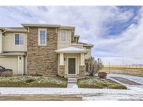 Inviting exterior of a two-story townhouse featuring a brick facade, covered entryway, and manicured landscaping at 13001 Grant Cir # C, Thornton, CO 80241