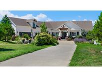 Charming white home with lush landscaping and a long driveway at 1935 Bashley Rd, Monument, CO 80132