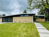 Modern home with a well-manicured lawn, brick facade, and unique architectural details at 6068 S Clayton St, Centennial, CO 80121
