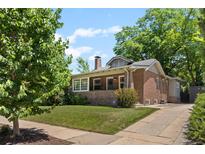 Charming brick home featuring a well-manicured lawn and a classic design under a partly cloudy sky at 864 Garfield St, Denver, CO 80206