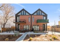 Modern townhome with a brick facade, black accents, balconies, and landscaping, under a clear blue sky at 4232 Jason St # 2, Denver, CO 80211