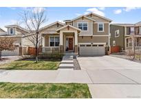 Charming two-story home featuring a covered porch, well-manicured lawn, and an attached two-car garage at 14938 Vienna Cir, Parker, CO 80134