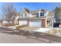 Charming townhome with a two-car garage and brick accents on a sunny day at 13068 Harrison Dr, Thornton, CO 80241