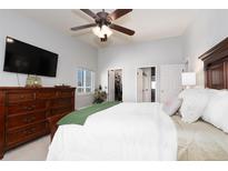 Bright main bedroom featuring a ceiling fan, walk-in closet, ensuite bathroom and a dresser with a TV at 3082 S Wheeling Way # 410, Aurora, CO 80014