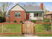 Charming brick home with a well-manicured lawn and a quaint wooden fence at 1456 Wabash St, Denver, CO 80220