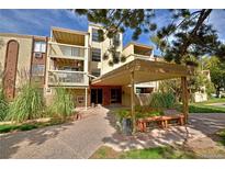 Two-story building with covered entryway, landscaping, and parking at 1306 S Parker Rd # 162, Denver, CO 80231