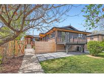 Beautiful home exterior featuring a modern deck, a well manicured lawn, and stylish accents under a clear blue sky at 2065 Depew St, Edgewater, CO 80214