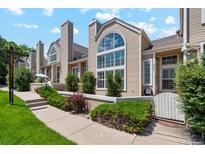 Inviting exterior view of townhome with large arched windows, lush landscaping, and well-maintained walkway at 5704 W Atlantic Pl, Lakewood, CO 80227