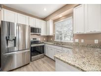 Stainless steel appliances and granite countertops highlight this updated kitchen at 6837 S Webster St # C, Littleton, CO 80128