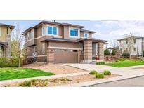 Inviting two-story home boasting an attached two-car garage, brick accents, and a well-kept lawn at 9570 Kendrick Way, Arvada, CO 80007