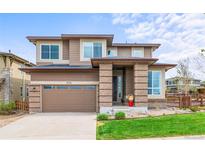 Beautiful two-story home featuring a brick facade, a two-car garage, and well-manicured lawn at 9570 Kendrick Way, Arvada, CO 80007
