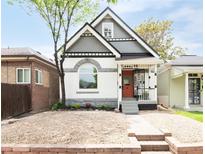 Charming two-story home showcasing a picturesque exterior with unique architectural details and landscaped front yard at 230 E Ellsworth Ave, Denver, CO 80209