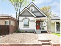 Charming two-story home with a unique architectural design, colorful accents, and a beautifully landscaped front yard at 230 E Ellsworth Ave, Denver, CO 80209