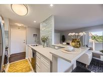Bright kitchen features stainless steel appliances, breakfast bar with seating, and access to living space at 937 N Clarkson St # 405, Denver, CO 80218