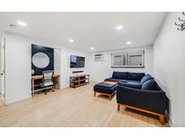 Bright living room features modern decor, stylish blue sectional couch, and wood-look floors at 20 S Logan St # 104, Denver, CO 80209