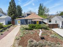 Charming home featuring mature landscaping and a bright yellow front door at 3941 S Elati St, Englewood, CO 80110