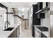 Modern kitchen with sleek countertops, stainless steel appliances, and an open staircase leading to the second floor at 5258 Lions Paw St, Castle Rock, CO 80104