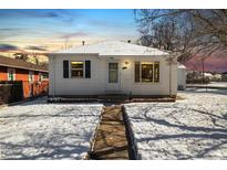 Charming home featuring a quaint front exterior with a walkway and snowy yard at 4100 Fenton St, Denver, CO 80212