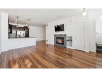 Spacious living room featuring hardwood floors and a cozy fireplace at 16285 W 62Nd Ln # C, Arvada, CO 80403
