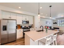 Stylish kitchen with stainless steel appliances, quartz countertops, and a large island at 24374 E 42Nd Ave, Aurora, CO 80019