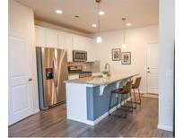 Modern kitchen features stainless steel appliances, granite countertops, and an island with seating at 15476 W 64Th Loop # C, Arvada, CO 80007