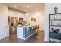 Bright kitchen features stainless steel appliances, stone countertops, and a breakfast bar with seating at 15476 W 64Th Loop # C, Arvada, CO 80007