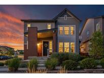 Charming two-story home features a brick accent wall, covered porch, and professionally landscaped front yard at 8846 Yates Dr, Westminster, CO 80031