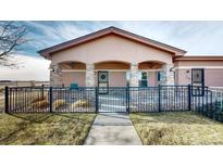 Charming home featuring a covered porch with stone pillars and black metal fencing at 15501 E 112Th Ave # 30A, Commerce City, CO 80022