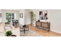 Bright living room featuring modern decor, stylish furniture, and abundant natural light, seamlessly flowing into the dining area at 2986 S Elm St, Denver, CO 80222