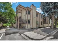 Two-story condo building featuring wood siding, a private entrance, and mature landscaping at 1111 S Garrison St # 202, Lakewood, CO 80232