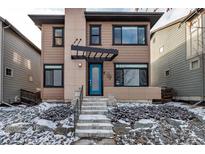 Contemporary two-story home featuring a covered entryway and a vibrant blue front door at 6715 Raritan Dr, Denver, CO 80221