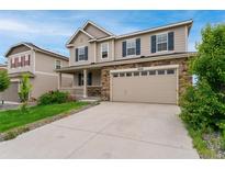 Charming two-story home featuring a stone facade, attached two car garage, and manicured front yard at 4666 S Malaya Ct, Aurora, CO 80015