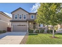 Charming two-story home with a manicured lawn, inviting front porch, and a two car garage at 12510 Fisher St, Englewood, CO 80112