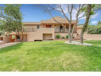 Beautifully landscaped home boasts a striking exterior with natural accents and a well-manicured lawn at 6201 Rain Dance Trl, Littleton, CO 80125