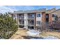 Lovely multi-story townhome featuring multiple balconies and a brick facade, with mature trees in the front yard at 8690 Decatur St # 305, Westminster, CO 80031