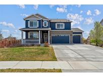 Charming two-story home featuring a welcoming front porch and a three-car attached garage at 7498 E 157Th Pl, Thornton, CO 80602