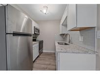 Modern kitchen featuring stainless steel appliances, granite countertops, and white cabinets at 4110 Hale Pkwy # 1E, Denver, CO 80220