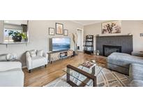 Bright living room with hardwood floors, modern furniture, and cozy fireplace at 1634 S Yukon Ct, Lakewood, CO 80232