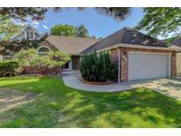 Charming brick home featuring a well-maintained lawn and an attached two-car garage at 6055 W Warren, Lakewood, CO 80227