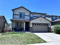 Charming two-story home featuring a two-car garage, landscaped front yard, and a welcoming front porch at 9923 Truckee St, Commerce City, CO 80022