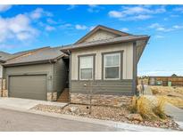 Charming home featuring stone accents, an attached garage, and tasteful landscaping, set against a blue sky at 11865 Barrentine Loop, Parker, CO 80138