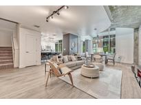 Bright living room boasts an open floor plan, with adjacent kitchen and dining areas, and modern decor at 1700 Bassett St # 101, Denver, CO 80202