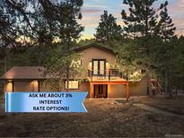 Charming multi-level home with a cozy deck nestled amongst the trees with beautiful sunset views at 30938 Niakwa Rd, Evergreen, CO 80439