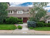 Charming two-story home with manicured lawn and mature trees, creating inviting curb appeal at 7750 S Glencoe Way, Centennial, CO 80122