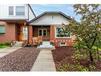 Charming brick home with a cozy front porch and landscaped front yard at 1463 Dahlia St # 2, Denver, CO 80220