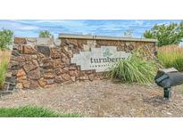 Stone community sign for Turnberry community with inviting landscaping and mailbox at 13392 E 110Th Way, Commerce City, CO 80022